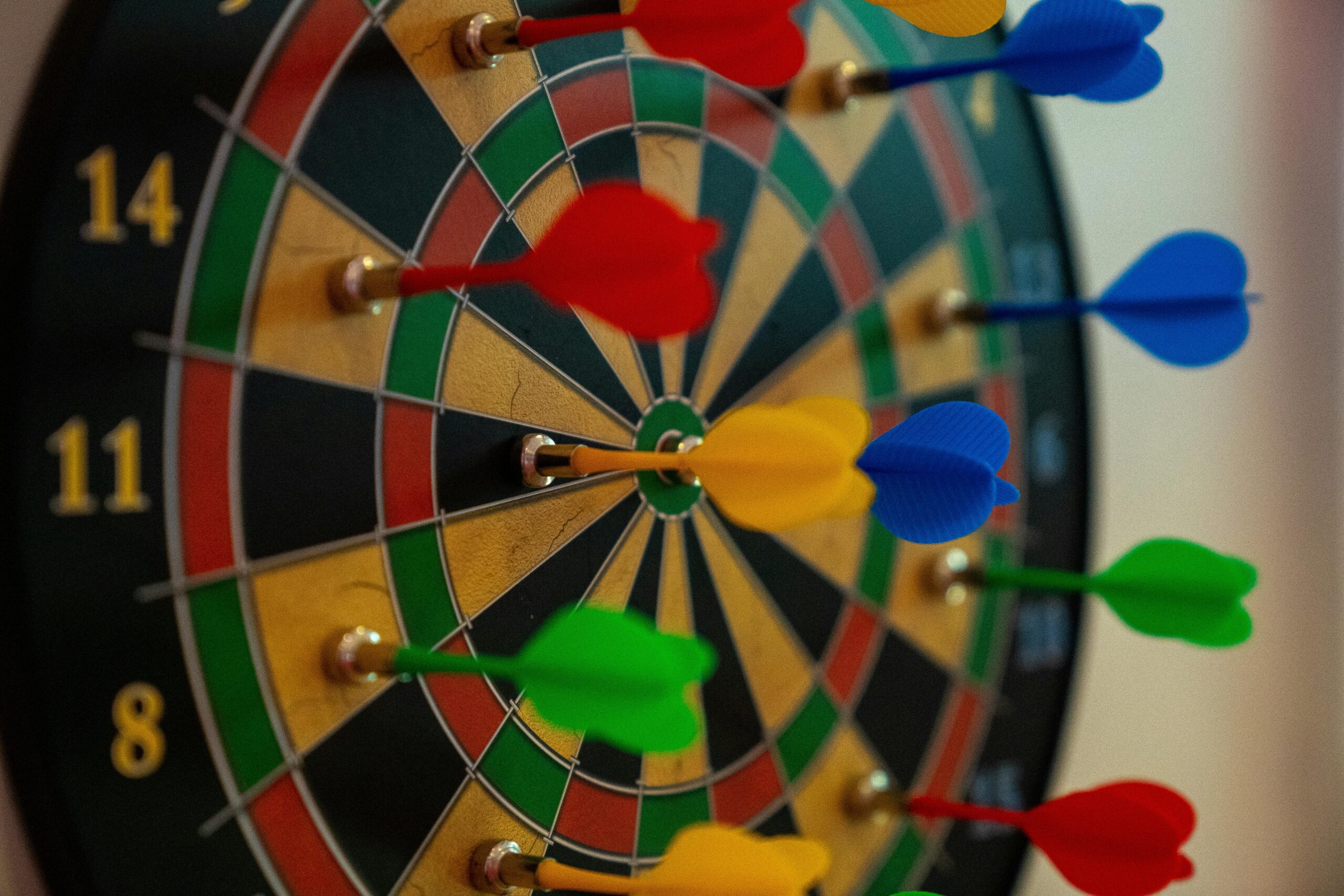 A close-up of vibrant colored darts on a dartboard, representing focus and precision in sports.